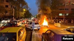 Sebuah sepeda motor polisi dibakar saat protes atas kematian Mahsa Amini, seorang perempuan yang meninggal setelah ditangkap oleh "polisi moral"di Teheran, Iran 19 September 2022. (Foto: WANA via REUTERS)