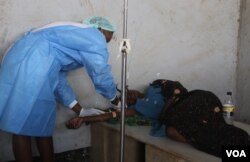 FILE - A health worker assists a cholera patient at Limbe Clinic in Blantyre, Malawi. (Lameck Masina/VOA)