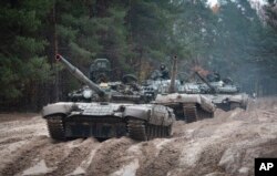 FILE - Ukrainian soldiers on captured Russian tanks T-72 hold military training close to the Ukraine-Belarus border near Chernihiv, Ukraine, Oct. 28, 2022.