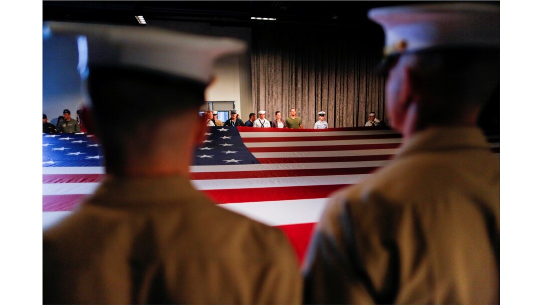 FILE - Army members hold the U.S. flag as they attend an annual Memorial Day ceremony at the Intrepid Museum in New York, May 29, 2017.