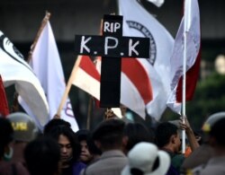 Seorang mahasiswa menunjukkan poster simbol kematian Komisi Pemberantasan Korupsi dalam demonstrasi di gedung DPR/MPR di Jakarta, 1 Oktober 2019. (Foto: AFP)