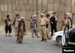 FILE - Members of the Afghan Local Police (ALP) keep watch at a checkpoint at Chardara district, in Kunduz province, Afghanistan, June 23, 2015.