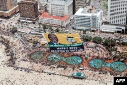 An aerial view shows a helicopter flying a giant flag of the South Africa's ruling African National Congress (ANC) displaying a picture of South African President Cyril Ramaphosa and urging people to register to vote for upcoming elections, in Durban, South Africa, Jan. 1, 2019.