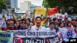 越南胡志明市民众高喊口号，抗议允许外国人在经济特区长期租赁土地的法律草案(2018年6月10日)
