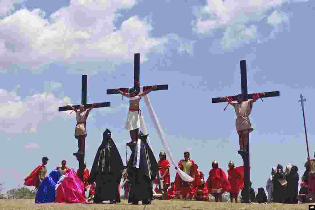 Penitentes en cruces de madera participan en una recreación de rituales del Viernes Santo en Cutud, provincia Pampanga, en el norte de las Filipinas. Foto AP.