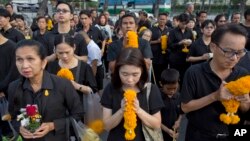 Thai mourners line up in front of a portrait of the late Thai King Bhumibol Adulyadej to pay respects outside the Grand Palace in Bangkok, Thailand, Oct. 13, 2017. Thais marked one year since the death of King Bhumibol with formal ceremonies and acts of personal devotion before an elaborate five-day funeral later this month.