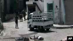 Citizen journalist merilis foto di mana beberapa tentara Suriah berdiri di antara penduduk yang tewas di desa Bayda, Kamis (2/5). 