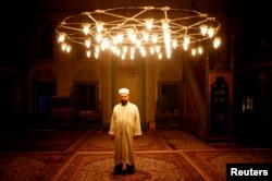 FILE - Effendi Ibranovic Dzemail poses for a photograph inside Sulejmanija Mosque in Travnik, Bosnia and Herzegovina, July 20, 2017.