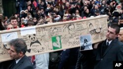 Pallbearers carry the casket of Charlie Hebdo cartoonist Bernard Verlhac, known as Tignous, decorated by friends and colleagues of the satirical newspaper Charlie Hebdo, at the city hall of Montreuil, outside east of Paris, Jan. 15, 2015. (AP Photo/Michel Euler)