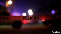 FILE - A police cordon that reads "Danger" is pictured at a crime scene where unknown assailants gunned down people at a garage in Ciudad Juarez, Mexico, Jan. 4, 2018. Homicides reached record levels last year in Mexico, and have climbed further this year, official data show.