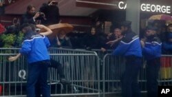 French police officers apprehend a topless protestor who ran toward the motorcade of President Donald Trump who was headed on the Champs Elysees to an Armistice Day Centennial Commemoration at the Arc de Triomphe, Nov. 11, 2018, in Paris.