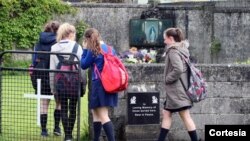 Estudiantes llegan al altar en memoria de los 800 menores encontrados en Tuam, Irlanda.