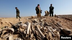 FILE - Bones, suspected to belong to members of Iraq's Yazidi community, are seen in a mass grave on the outskirts of the town of Sinjar, Nov. 30, 2015. 