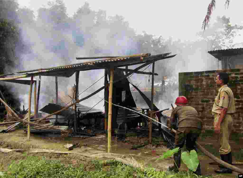 Indian firefighters try to put out a fire at a police station in Kokrajhar, India, July 24, 2012. 
