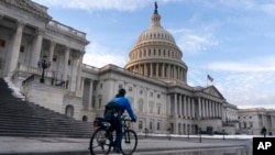 A US Capitol Police bicycle officer patrols the plaza, on the East Front of the US Capitol, Jan. 5, 2022, in Washington. 