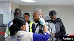 Seorang pelancong tiba di Bandara Internasional Toussaint Louverture, Port-au-Prince, diperiksa suhunya sebagai bagian dari langkah-langkah untuk mencegah masuknya virus corona di Haiti, 4 Februari 2020. (Foto: Reuters/Valerie Baeriswyl)