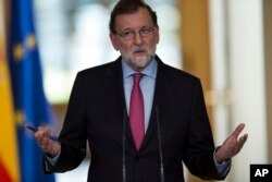 FILE - Spain's Prime Minister Mariano Rajoy gestures as he talks to journalists during a news conference in Madrid, Dec. 29, 2017.