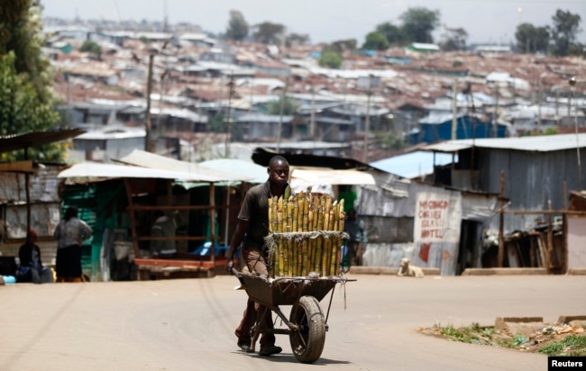 FILE - A vendor sells sugar cane in Kibera slum in Kenya's capital Nairobi, March 7, 2014.