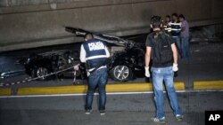 Police look at a car crushed under a collapsed overpass in Guayaquil, Ecuador, Saturday April 16, 2016. The strongest earthquake to hit Ecuador in decades flattened buildings and buckled highways along the country's coast, killing scores of people and causing damage hundreds of kilometers away from the epicenter in the capital and other major cities.(AP Photo/Jeff Castro)