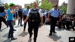 St. Louis Police Chief Sam Dotson pushes the media and others back as protesters are arrested outside the Thomas F. Eagleton Federal Courthouse, Aug. 10, 2015, in St. Louis.