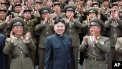 In this Tuesday, May 1, 2012 photo released by the Korean Central News Agency and distributed by the Korea News Service Wednesday, May 2, 2012, North Korea's leader Kim Jong Un, center, is applauded by military personnel during his visit to the Machine Pl
