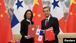 中国外长王毅（右）和巴拿马副总统兼外交部长伊莎贝尔·德圣马洛在北京签署两国建立外交关系的联合公报。（2017年6月13日）