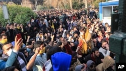 In this Saturday, Dec. 30, 2017 file photo taken by an individual not employed by the Associated Press and obtained by the AP outside Iran, university students attend a protest inside Tehran University while anti-riot Iranian police prevent them to join o