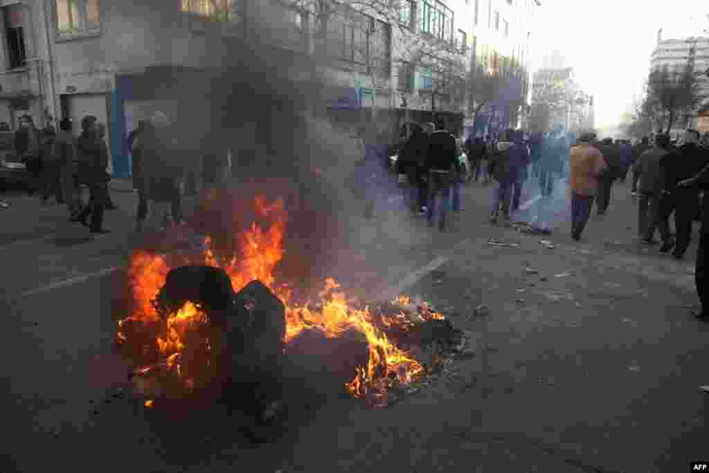 A dumpster burns on a street near Azadi Square in Tehran