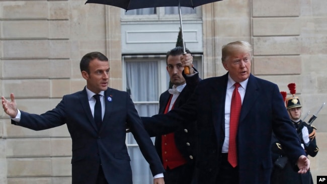 美国总统特朗普在抵达巴黎爱丽舍宫时受到法国总统马克龙的欢迎。（2018年11月10日）