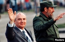FILE - Then-Soviet leader Mikhail Gorbachev and then Cuban leader Fidel Castro wave from an open top car as it drives through Havana's Revolution Square, April 2, 1989.