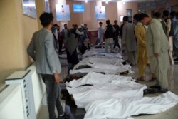 Afghan men try to identify the dead bodies at a hospital after a bomb explosion near a school west of Kabul, Afghanistan, Saturday, May 8, 2021. A bomb exploded near a school in west Kabul on Saturday, killing several people, many them young students