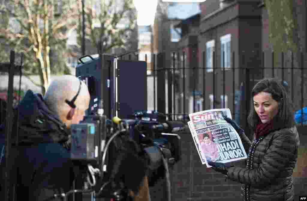 A journalist holds up a newspaper as she does a report outside a London home on February 27, 2015, where Kuwaiti-born computer programmer Mohammed Emwazi, identified by experts and the media as masked Islamic State militant &quot;Jihadi John,&quot; is once believed to have lived.