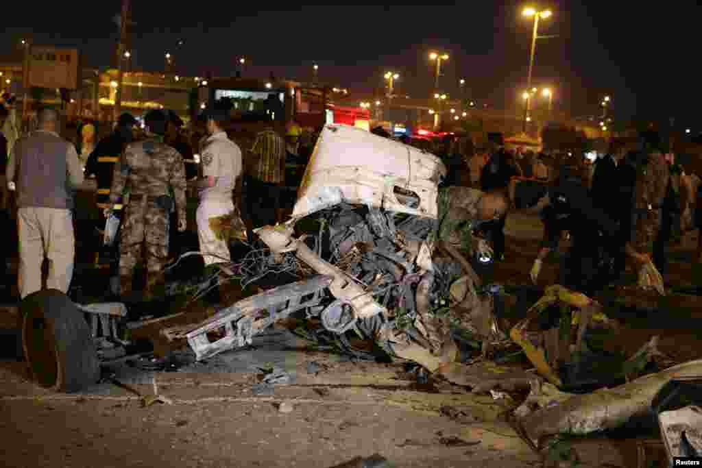 Iraqi security forces personnel inspect the site of a bomb attack in Najaf, south of Baghdad, April 25, 2013.