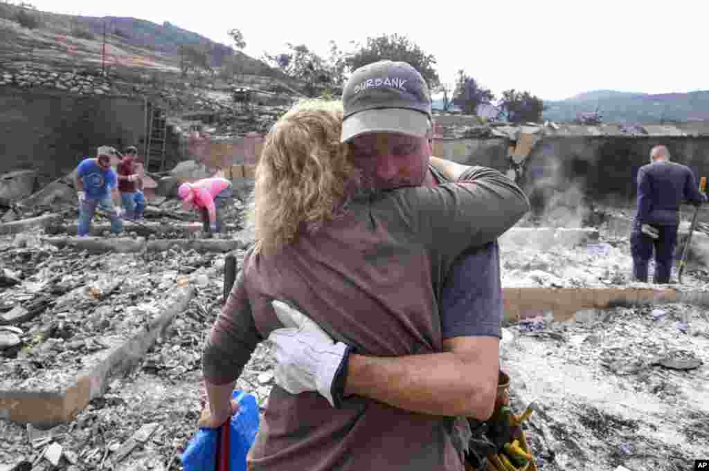Craig Bolleson hugs his friend in his burned out home, Monday, Sept. 4, 2017, in the Sunland-Tujunga section of Los Angeles. 