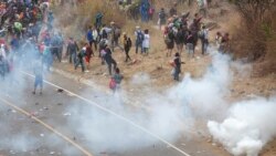 Honduran migrants hurl stones at Guatemalan soldiers amid tear gas in Vado Hondo, Guatemala, Sunday, Jan. 17, 2021.