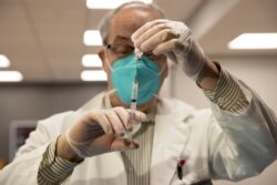 Apoteker CVS Gerard Diebner menyiapkan vaksin COVID-19 untuk penghuni panti jompo di Harlem Center for Nursing and Rehabilitation, fasilitas panti jompo, pada 15 Januari 2021, di New York. (Foto: AP)