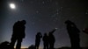 امریکی ریاست سیڈورا کے علاقے میں لوگ رات کے وقت آسمان پر ایک چمکتی ہوئی پراسرار چیز کا مشاہدہ کر رہے ہیں۔ فائل فوٹو