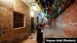 Hajah Dalal Abdelqader, seorang Mesaharati berusia 46 tahun, menabuh genderang untuk membangunkan umat Islam untuk sahur sebelum mereka memulai puasa Ramadhan, di Maadi di Kairo, Mesir, 13 April 2021 (Foto: REUTERS/Hayam Adel)