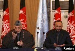 Former Afghan president Hamid Karzai, left, and former national security adviser Haneef Atmar, seen here offering prayers at a forum in Kabul, Feb. 12, 2008, are among influential Afghans expected to attend the Moscow talks.