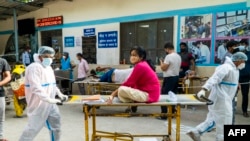 Na fotografiji snimljenoj 23. aprila 2021. bolničko osoblje prevozi pacijenta s Covid-19 koronavirusom u bolnički kompleks u New Delhiju. (Foto Maude BRULARD / AFP)