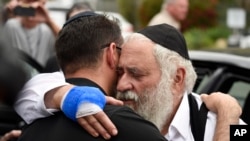 Rabbi Yisroel Goldstein, right, is hugged as he leaves a news conference at the Chabad of Poway synagogue, Sunday, April 28, 2019, in Poway, California. (AP Photo/Denis Poroy)