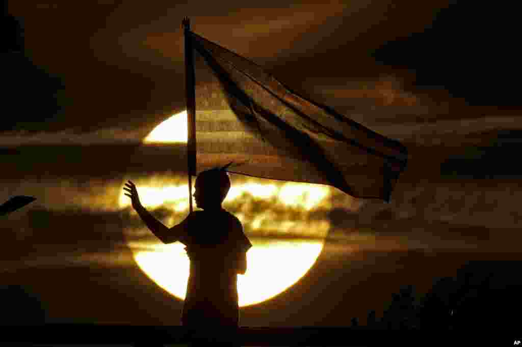 A boy waves to passing motorists to commemorate the anniversary of the Sept. 11 terrorist attacks from an overpass on Interstate 35, Sept. 11, 2019, near Melvern, Kansas.