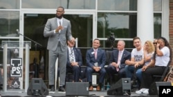 LeBron James speaks and gets a laugh from his mother, Gloria, right, at the opening ceremony for the I Promise School in Akron, Ohio, July 30, 2018.