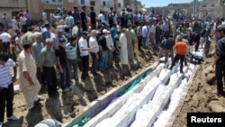 People gather at a mass burial for the victims purportedly killed during an artillery barrage from Syrian forces in Houla in this handout image provided by Shaam News Network, May 26, 2012.