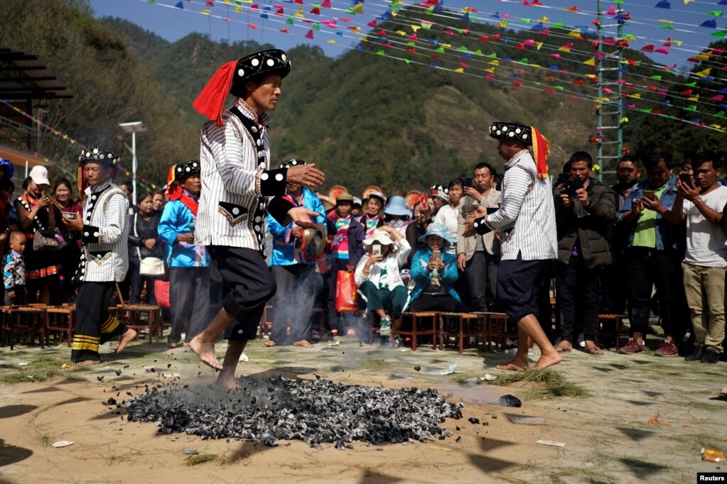 중국 운남성 누쟝리수족자치주 루장마을 에서 매년 열리는 나이프 폴 축제 중 리수족의 남성이 뜨거운 숯불 위에서 춤을 추고 있다.