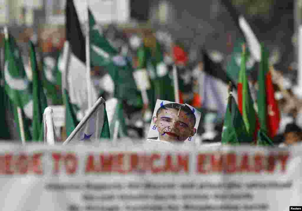 18일 인도 남부 첸나이에서 반미 시위가 벌어진 가운데, 이슬람 교도들이 바락 오바마 미국 대통령의 얼굴을 훼손한 포스터를 들고 있다.