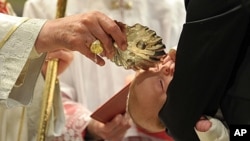 Pope Benedict XVI baptizes one of 21 newborns during in the Sistine Chapel, the Vatican, Jan. 9, 2011 (file photo).