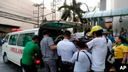 ARCHIVES - Des agents de sécurité et de santé transportent une employée vers une ambulance après le tremblement de terre qui a frappé Manille, aux Philippines, lundi 22 avril 2019. 