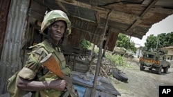 A Ugandan soldier serving with the African Union Mission in Somalia stands guard during the removal of a haul of 155mm artillery shells that were found in a house deep inside a former al-Shabab stronghold in the Somali capital Mogadishu, August 12, 2011