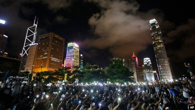 Protesters wave their mobile phones during a rally, after China's legislature has ruled out open nominations in elections for Hong Kong's leader in Hong Kong, Aug. 31, 2014.